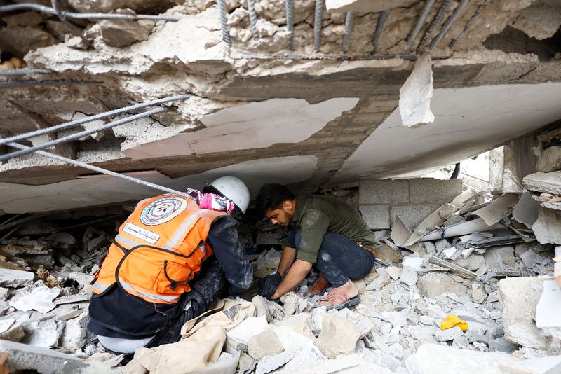 © Reuters. An Emergency worker and a Palestinian man check the damage at the site of Israeli strikes on houses, amid the ongoing conflict between Israel and Palestinian Islamist group Hamas, in Khan Younis in the southern Gaza Strip, October 29, 2023. REUTERS/Mohammed Salem