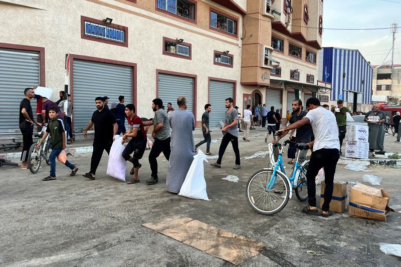 &copy; Reuters. Palestinos transportan alimentos cerca de un almacén gestionado por la Agencia de Naciones Unidas para los Refugiados Palestinos (UNRWA) en Jan Yunis, en el sur de la Franja de Gaza, el 28 de octubre de 2023.  REUTERS/Ibraheem Abu Mustafa