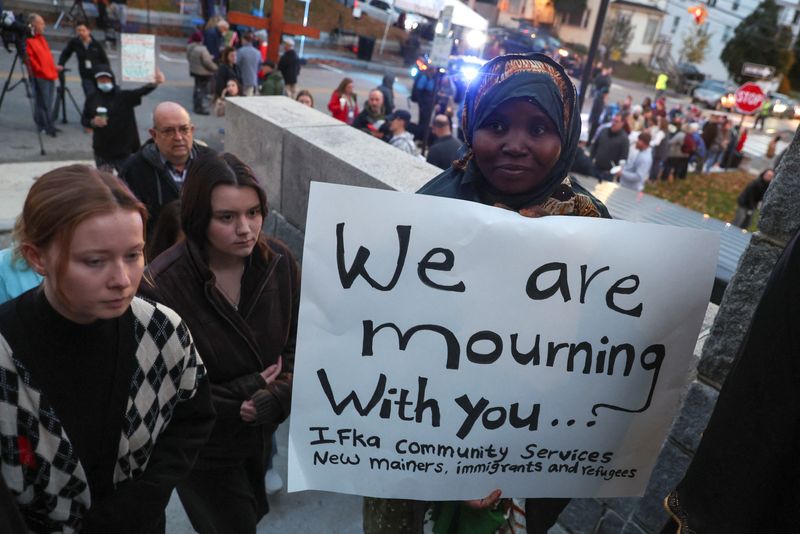 &copy; Reuters. A person holds a placard as mourners take part in a vigil for the victims of the deadly mass shooting outside the Basilica of Saints Peter and Paul, in Lewiston, Maine, U.S., October 29, 2023. REUTERS/Shannon Stapleton
