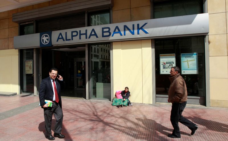 &copy; Reuters. Una mendicante di fronte ad una filiale di Alpha bank ad Atene. 14 marzo 2012. REUTERS/John Kolesidis/File Photo