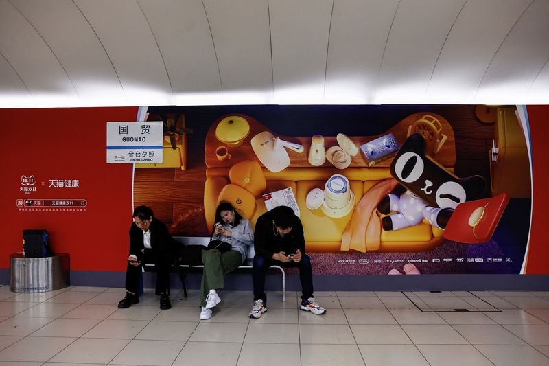 &copy; Reuters. People sit near an Alibaba's advertisement promoting Singles Day shopping festival, at a subway station in Beijing, China October 26, 2023. REUTERS/Tingshu Wang