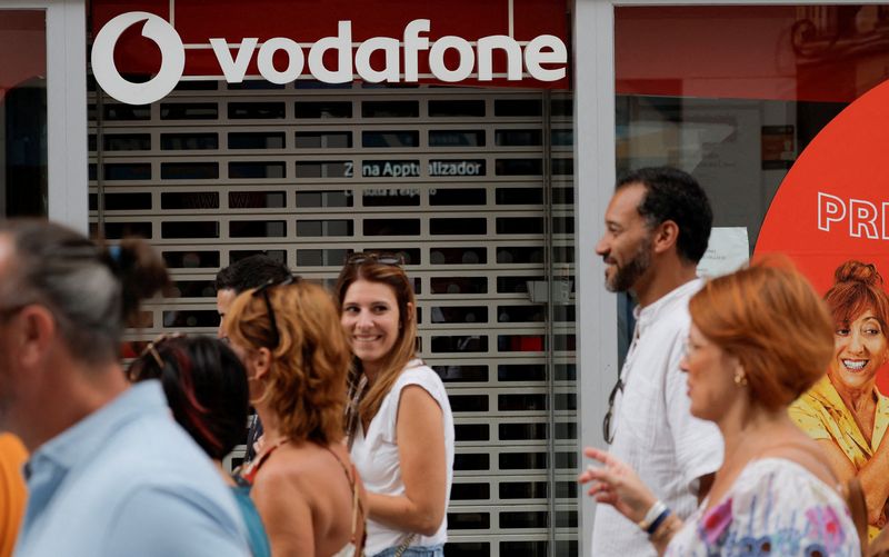 &copy; Reuters. FILE PHOTO: People walk past a Vodafone store in Ronda, Spain, October 3, 2022. REUTERS/Jon Nazca/File Photo