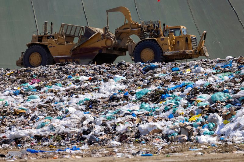 &copy; Reuters. FILE PHOTO: Workers use heavy machinery to move trash and waste at the Frank R. Bowerman landfill on Irvine, California, U.S., June 15, 2021.Picture taken June 15, 2021.     REUTERS/Mike Blake/File Photo