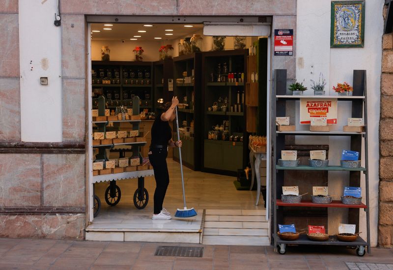 &copy; Reuters. A saleswoman sweeps the floor for the opening of a spice shop in downtown Ronda, Spain, October 3, 2023. REUTERS/Jon Nazca