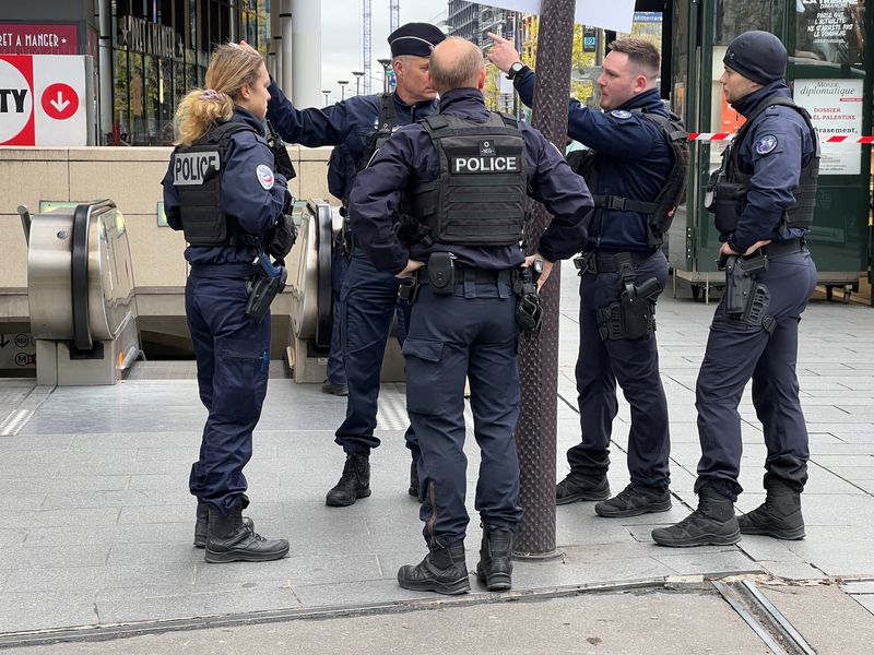 © Reuters. Un grupo de policias frente a la estación de metro y tren regional Bibliotheque Francois Mitterand, donde los agentes dispararon e hirieron a una mujer con hiyab después de que gritara 