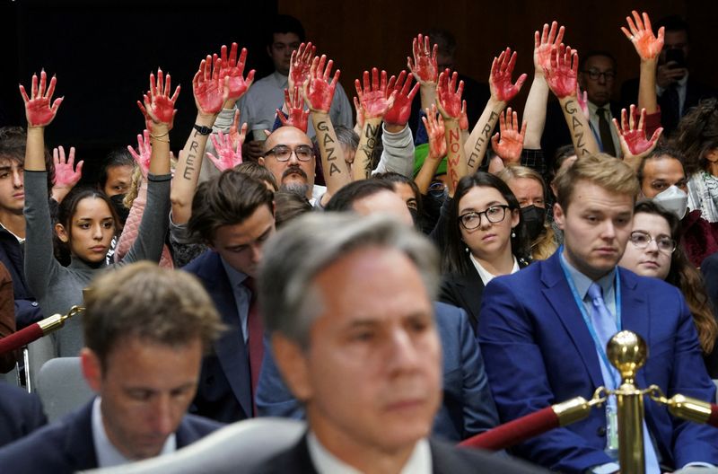 © Reuters. Anti-war protesters raise their 