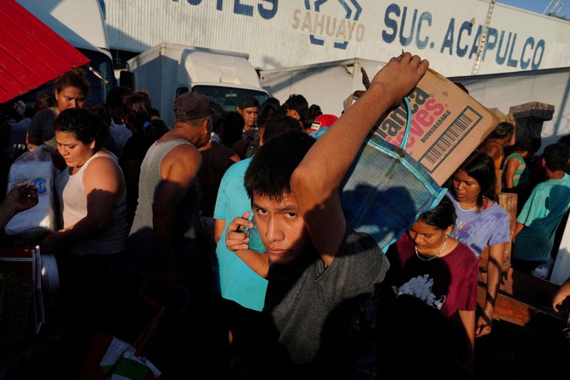 &copy; Reuters. FILE PHOTO: People leave with goods from a supermarket that had been broken into in the aftermath of Hurricane Otis, in the outskirts of Acapulco, Mexico, October 26, 2023. REUTERS/Alexandre Meneghini/File Photo