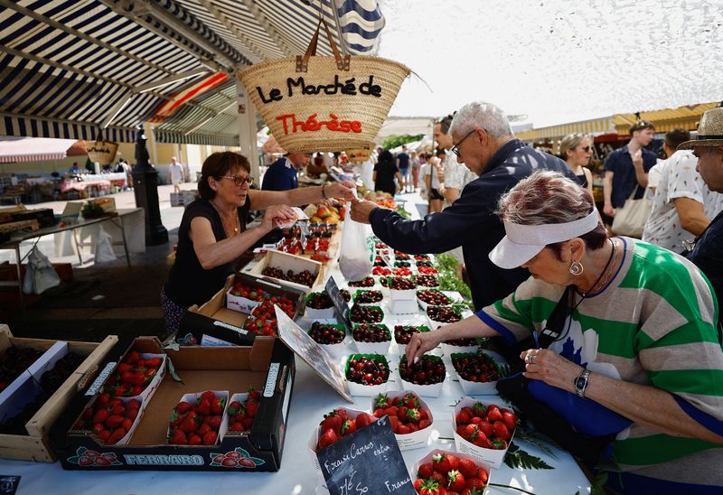 &copy; Reuters. متسوقون يشترون الفواكه في سوق محلي في نيس بفرنسا يوم الثامن من يونيو حزيران 2023. تصوير: إريك جيلارد - رويترز.