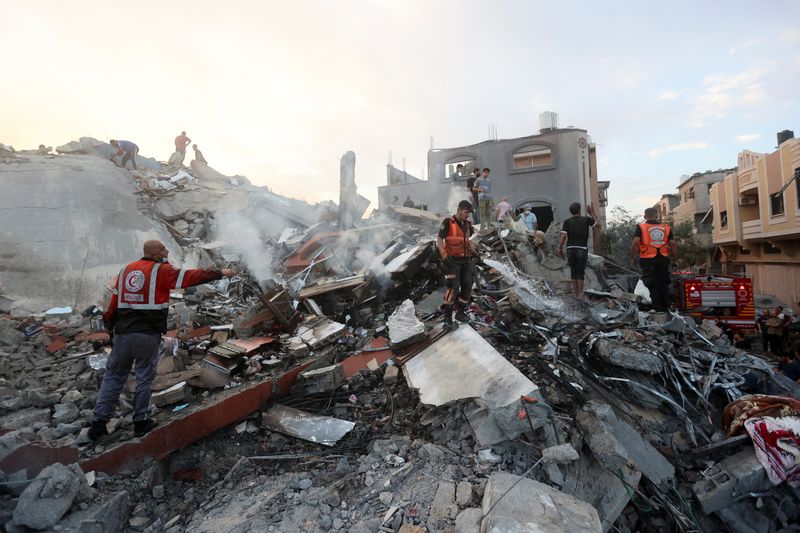 &copy; Reuters. Palestinians conduct search and rescue operations at the site of Israeli strikes on a residential building, in the central Gaza Strip October 31, 2023. REUTERS/Ahmed Zakot