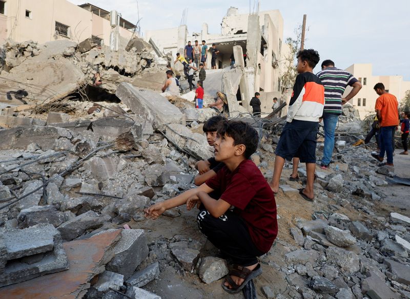 &copy; Reuters. Palestinos observam destroços de prédio destruído em ataque israelense em Khan Younis
17/10/2023
REUTERS/Mohammed Salem