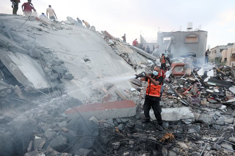 &copy; Reuters. Palestinos llevando a cabo operaciones de búsqueda y rescate en el lugar de los ataques israelíes contra un edificio residencial, en el centro de la Franja de Gaza. 31 de octubre de 2023. REUTERS/Ahmed Zakot