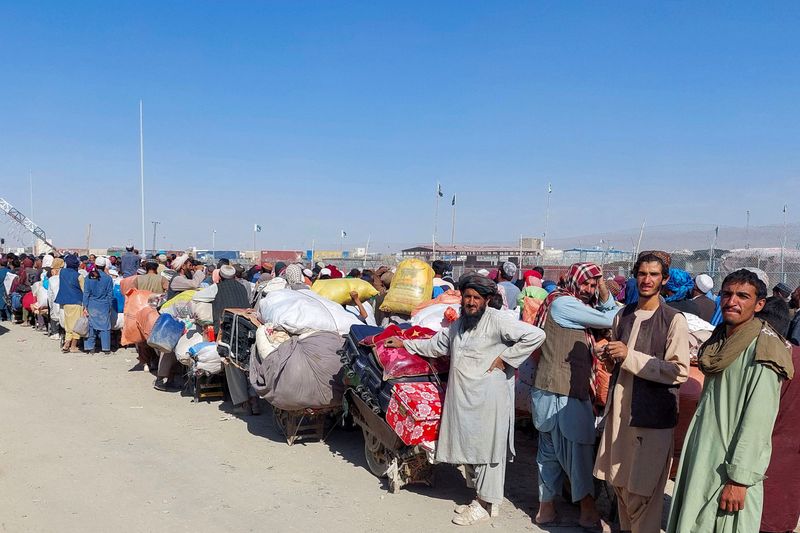 © Reuters. مواطنون أفغان ينتظرون مع أمتعتهم للعبور إلى أفغانستان عند معبر شامان الحدودي في مقاطعة بلوخستان بباكستان يوم الثلاثاء. تصوير: عبد الخالق أشاكزاي - رويترز.
