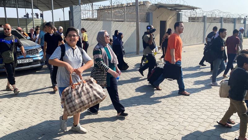 &copy; Reuters. فلسطينيون من حاملي جوازات السفر الأجنبية يعبرون  إلى الجانب المصري من معبر رفح من غزة يوم الأربعاء. تصوير : عرفات بربخ - رويترز .    
