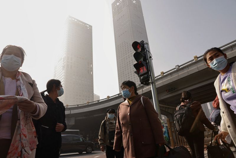 &copy; Reuters. Personas con mascarillas esperan en una intersección del Distrito Central de Negocios (CBD) de Pekín, mientras la ciudad está envuelta en niebla tóxica, en China el 1 de noviembre de 2023. REUTER/Tingshu Wang