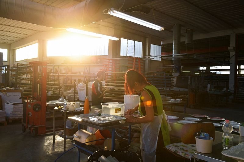 &copy; Reuters. FILE PHOTO: Employees work at a ceramics factory where the workers start their shifts before dawn to optimise sunlight and save energy, in Citta di Castello, Italy, August 30, 2022. REUTERS/Jennifer Lorenzini/File Photo