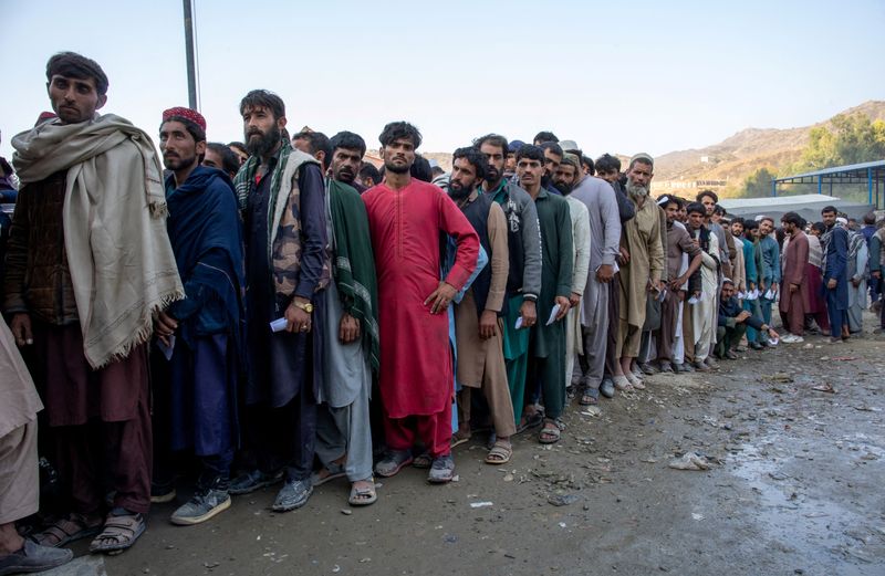 &copy; Reuters. أفغانستانيون يقفون في طابور خلال انتظارهم للخضوع للفحص للوصول إلى المساعدات الإنسانية عند معبر طورخم الحدودي بين باكستان وأفغانستان يوم 30 