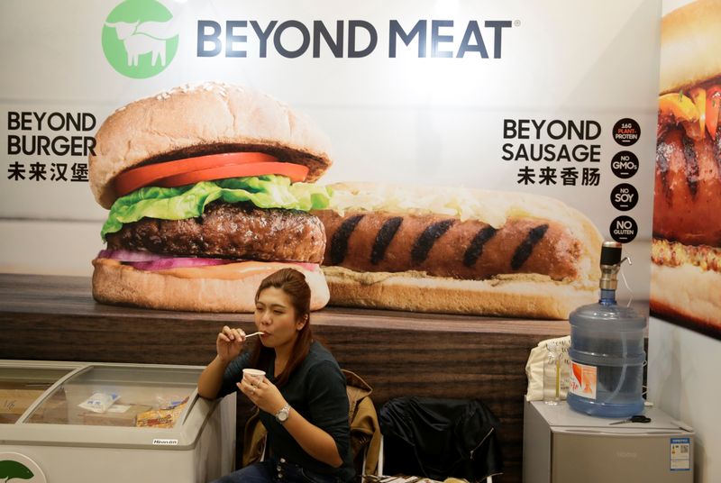 &copy; Reuters. FILE PHOTO: A woman sits next to a poster at the booth of plant-based food company Beyond Meat at VeggieWorld fair in Beijing, China November 8, 2019.  REUTERS/Jason Lee