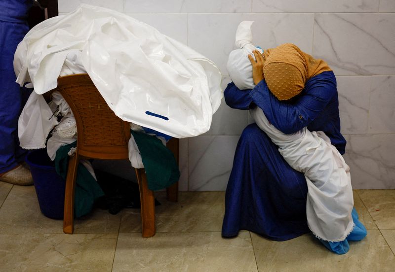 &copy; Reuters. La palestina Inas Abu Maamar, de 36 años, abraza el cuerpo de su sobrina Saly, de 5 años, muerta en un ataque israelí, en el hospital Nasser de Khan Younis, en el sur de la Franja de Gaza, el 17 de octubre de 2023

REUTERS/Mohammed Salem  