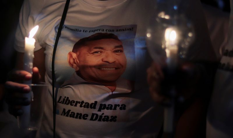 &copy; Reuters. شخص يحمل الشموع ويشارك في وقفة احتجاجية للمطالبة بالإفراج عن والد لاعب ليفربول المهاجم لويس دياز بعد اختطافه في بارانكاس بكولومبيا يوم الأ