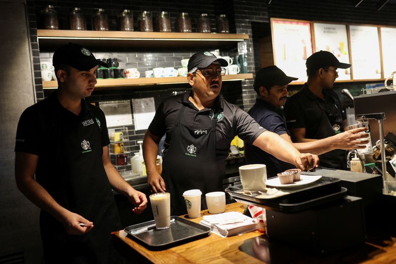 &copy; Reuters. FILE PHOTO: An employee stakes a customer's order as others make drinks at a Starbucks' outlet at a market in New Delhi, India, May 30, 2023. REUTERS/Anushree Fadnavis/File Photo