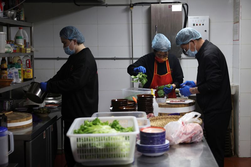 &copy; Reuters. Employees prepare meat and vegetables at a kitchen of a hotpot restaurant in Beijing, China April 8, 2022. Picture taken April 8, 2022. REUTERS/Tingshu Wang/File Photo
