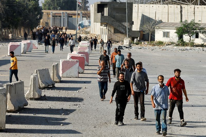 &copy; Reuters. بعض العمال الفلسطينيين من سكان غزة يصلون إلى معبر رفح الحدودي بجنوب قطاع غزة يوم الجمعة عقب قيام  إسرائيل باعادتهم  إلى القطاع . تصوير : إبراه