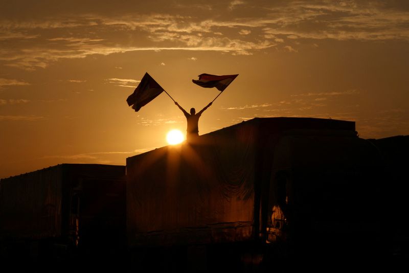 &copy; Reuters. Des camions transportant de l'aide humanitaire pour les Palestiniens sont vus le jour de la visite du Premier ministre égyptien Mostafa Madbouly au poste frontière de Rafah entre l'Égypte et la bande de Gaza, dans le cadre du conflit actuel entre Isra