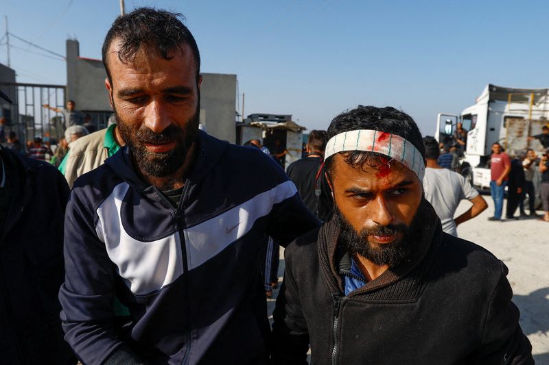 © Reuters. Un jornalero palestino, Khaled al-Bahnasi, que se encontraba en Israel durante el atentado de Hamás del 7 de octubre, que dice que fue golpeado en la cabeza por las fuerzas israelíes, es recibido a su llegada a la frontera de Rafah, en el sur de la Franja de Gaza. 3 de noviembre de 2023. REUTERS/Ibraheem Abu Mustafa