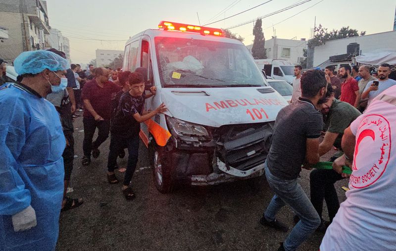 &copy; Reuters. فلسطينيون يسحبون سيارة إسعاف بعد قصف قافلة سيارات إسعاف عند مدخل مستشفى الشفاء في مدينة غزة يوم الجمعة. تصوير: أنس الشريف - رويترز.
