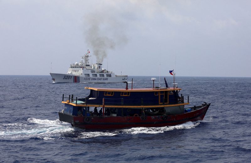 &copy; Reuters. FILE PHOTO: A Philippine supply boat sails near a Chinese Coast Guard ship during a resupply mission for Filipino troops stationed at a grounded warship in the South China Sea, October 4, 2023. REUTERS/Adrian Portugal/File Photo