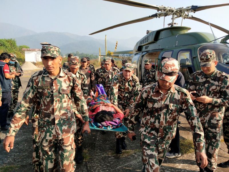 © Reuters. 　ネパール西部ジャージャルコートで３日深夜、強い地震が発生し、当局者によると少なくとも１２８人が死亡した。写真はジャージャルコートで負傷者を移送する軍兵士（２０２３年　ロイター/Nepal Army）