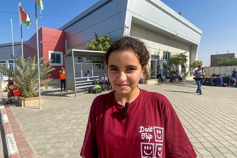 &copy; Reuters. فرح صلوحة (11 عاما) أمريكية من أصل فلسطيني تتحدث إلى أحد المراسلين قبل ركوب الحافلة للمغادرة إلى مصر عند معبر رفح الحدودي بجنوب قطاع غزة يوم ا