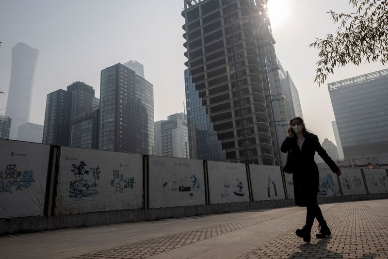 &copy; Reuters. A woman walks in the Central Business District (CBD) on a hazy morning in Beijing, China, October 25, 2021.   REUTERS/Thomas Peter/File Photo