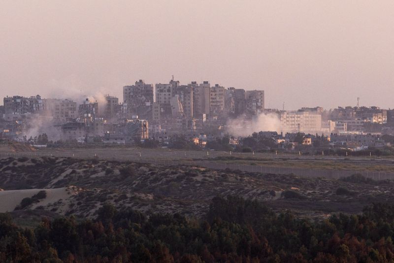 © Reuters. دخان يتصاعد وسط مباني مدمرة في قطاع غزة يمكن رؤيته من جنوب إسرائيل يوم السبت. تصوير: عامير كوهين - رويترز