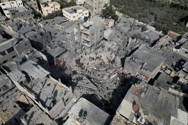 &copy; Reuters. فلسطينيون يبحثون عن ضحايا في منازل دمرت من الهجمات الإسرائيلية وسط الصراع المستمر بين إسرائيل وحركة حماس الإسلامية الفلسطينية، في مخيم الم
