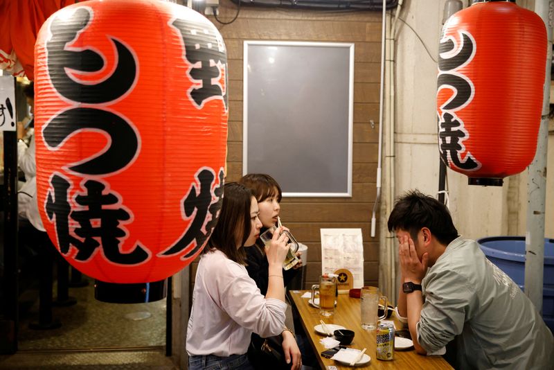 © Reuters. People eat at an outdoor table of a restaurant in Tokyo, Japan, March 21, 2023. REUTERS/Androniki Christodoulou/File Photo