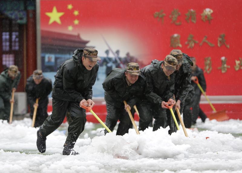 &copy; Reuters. Des policiers paramilitaires travaillent au déneigement, dans le centre de Pékin. /Photo prise le 4 novembre 2012/REUTERS/Jason Lee