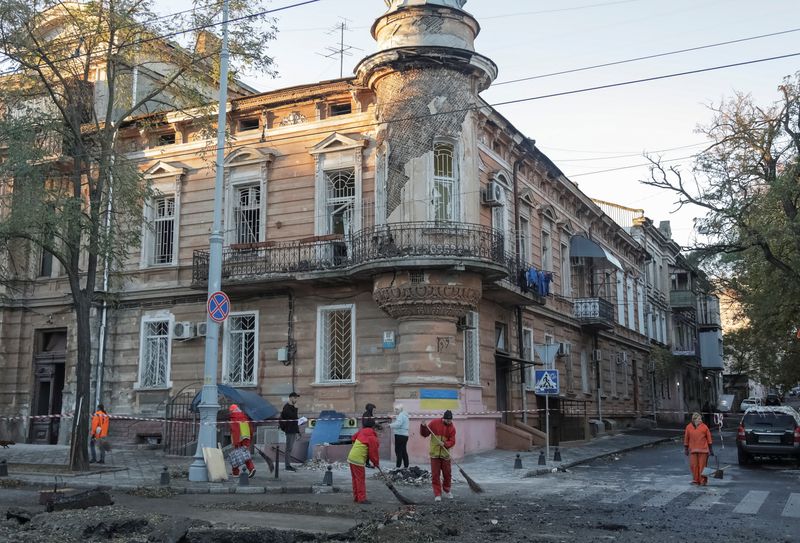 © Reuters. عمال البلدية ينظفون منطقة تعرضت لقصف صاروخي روسي في أوديسا بأوكرانيا يوم الاثنين. تصوير: نينا لياشونوك - رويترز.