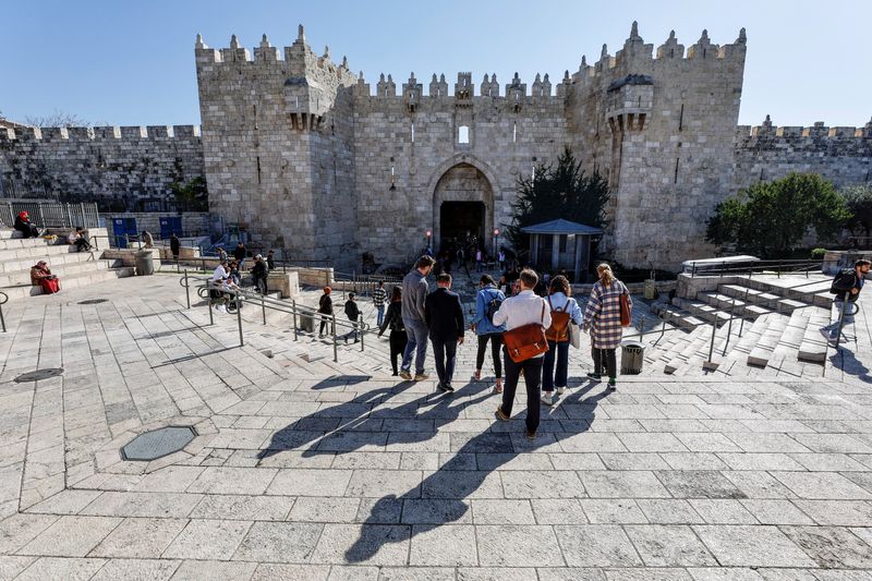 &copy; Reuters. A group of tourists descends the stairs leading to the Damascus Gate, in Jerusalem's Old City, December 11, 2022. REUTERS/Ammar Awad/