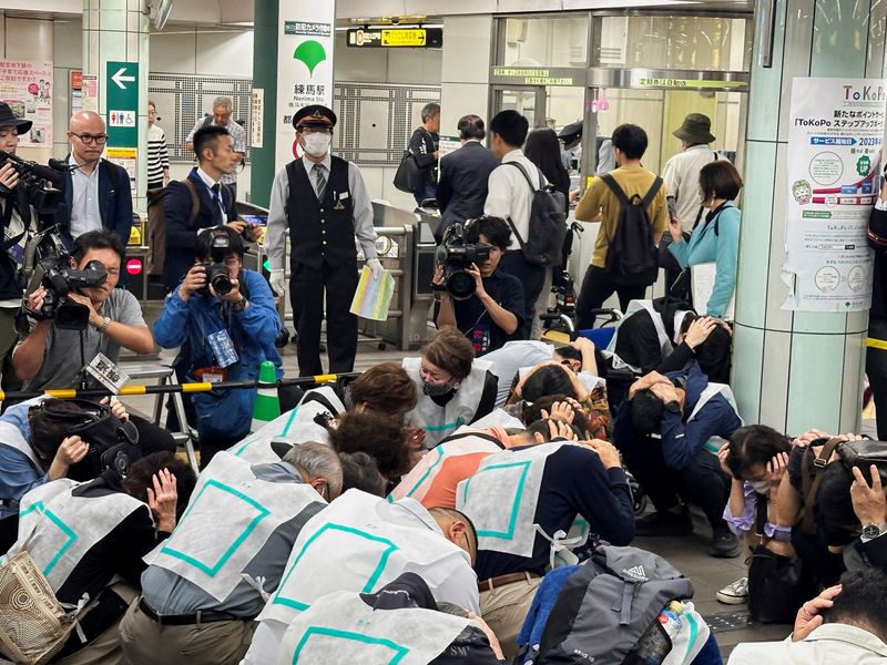 &copy; Reuters. سكان من طوكيو يغطون رؤوسهم ويحتمون داخل محطة قطار في إطار أول تدريب على الإخلاء في العاصمة اليابانية يوم الاثنين. تصوير: فرنسيس تانغ - رويترز