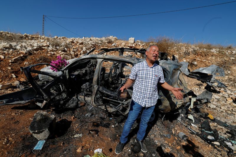 © Reuters. Samir Ayoub, uncle of three Lebanese girls killed along with their grandmother yesterday, by what he says was an Israeli airstrike that targeted their car in which they were traveling between Aytaroun and Aynata, speaks as he mourns them beside the burned car near the Lebanon and Israel border, in the outskirts of the southern town of Aynata, Lebanon November 6, 2023. REUTERS/Zohra Bensemra