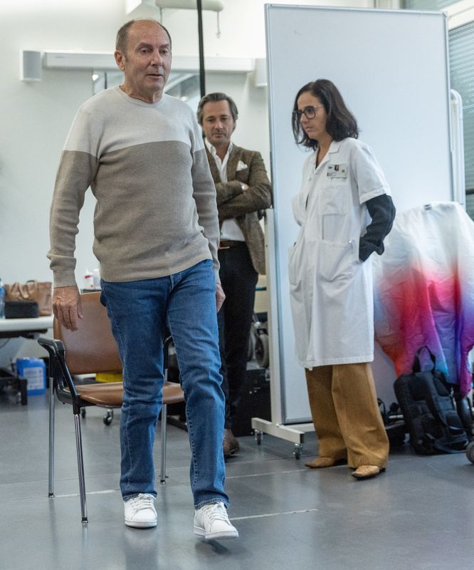 &copy; Reuters. Marc Gauthier, 63, the first patient with a neuroprosthetic, programmed to stimulate his spinal cord to correct walking disorders caused by Parkinson's disease, stands up in front of Gregoire Courtine, professor of neuroscience at the Swiss Federal Instit