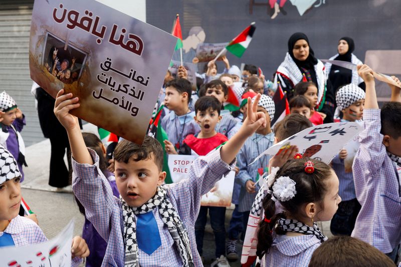 &copy; Reuters. Des enfants portent des bannières et des drapeaux lors d'une manifestation de solidarité avec les Palestiniens de Gaza, dans le cadre du conflit actuel entre Israël et le groupe islamiste palestinien Hamas, devant les bureaux de la Croix-Rouge à Beyro