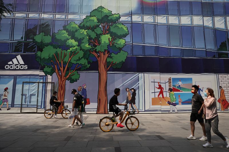 © Reuters. People walk past an Adidas store to be opened, at a shopping area during Dragon Boat Festival holiday, following the coronavirus disease (COVID-19) outbreak, in Beijing, China June 3, 2022. REUTERS/Tingshu Wang/fILE pHOTO