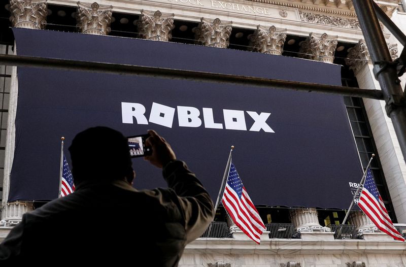 &copy; Reuters. A man photographs a Roblox banner displayed, to celebrate the company's IPO, on the front facade of the New York Stock Exchange (NYSE) in New York, U.S., March 10, 2021. REUTERS/Brendan McDermid/ File Photo