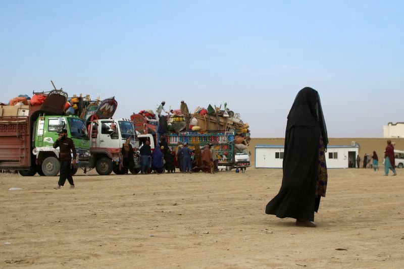 &copy; Reuters. امرأة أفغانية ترتدي البرقع تسير أمام شاحنات محملة بالممتلكات بينما يعود المواطنون الأفغان في باكستان إلى أفغانستان في مقاطعة بلوشستان في ت