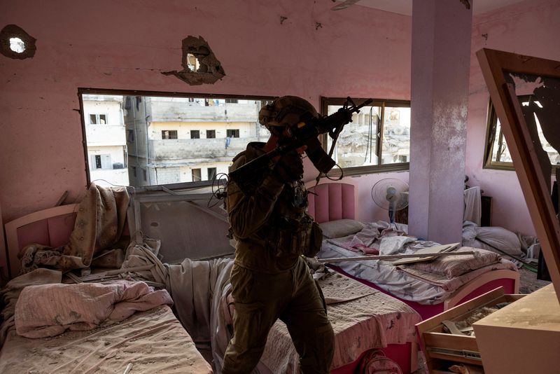 &copy; Reuters. اللفتنانت كولونيل إيدو يقف في غرفة نوم أطفال مطلية باللون الوردي لحقت بها أضرار بالغة، يقول إن تحتها طابقان من الورش التي كانت تستخدم لتصني