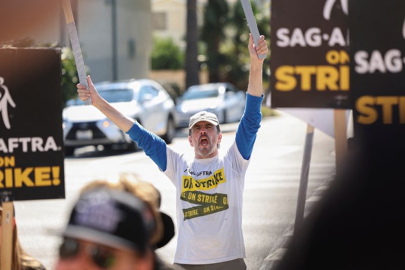 &copy; Reuters. FILE PHOTO: SAG-AFTRA member Jim Kulick reacts as he and other SAG-AFTRA members walk the picket line on the 100th day of their ongoing strike, outside Paramount Studios in Los Angeles, California, U.S., October 20, 2023. REUTERS/Mario Anzuoni/File Photo