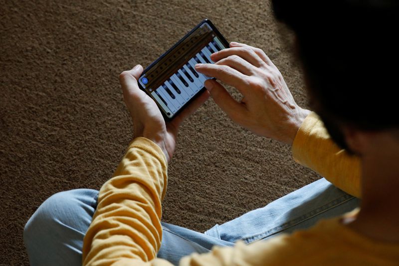 &copy; Reuters. Saleh Zada, 32, a singer and songwriter, who was born in Badakhshan province and later moved to Kabul for his education, plays a music composition on his mobile harmonium app during an interview with Reuters, in Karachi, Pakistan November 4, 2023. REUTERS