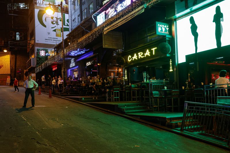 &copy; Reuters. FILE PHOTO: Bar staff members stand in the middle of the road to promote their bars and restaurants in Lan Kwai Fong, a popular nightlife destination, in the financial central district of Hong Kong, China October 3, 2023. REUTERS/Tyrone Siu